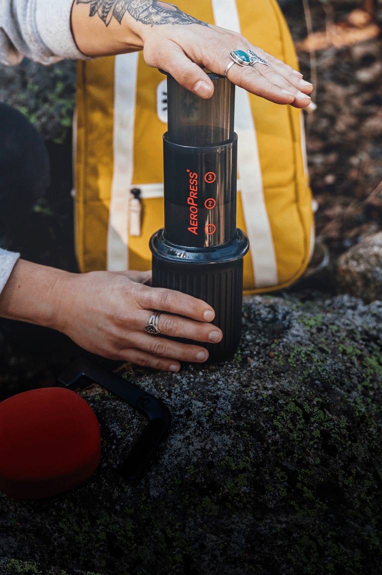 A person brews coffee with the AeroPress Go Travel coffee press