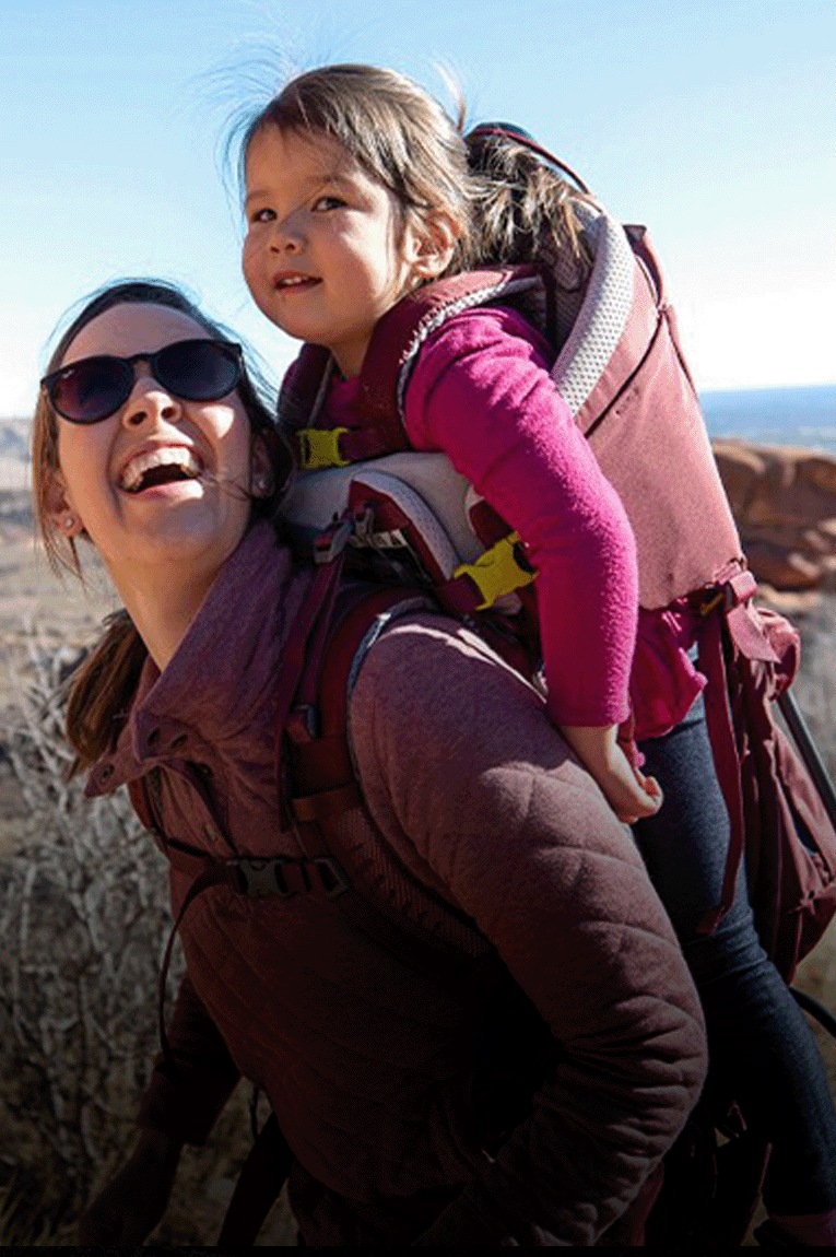A person carries a child in the Deuter Kid Comfort Child Carrier