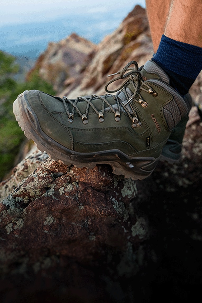 A hiker wears the Lowa Renegade GTX Mid Hiking Boot on a rocky trail
