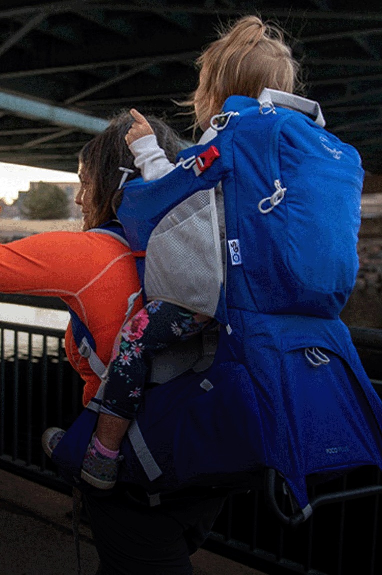 A person carries a child in the Osprey Poco Plus Child Carrier
