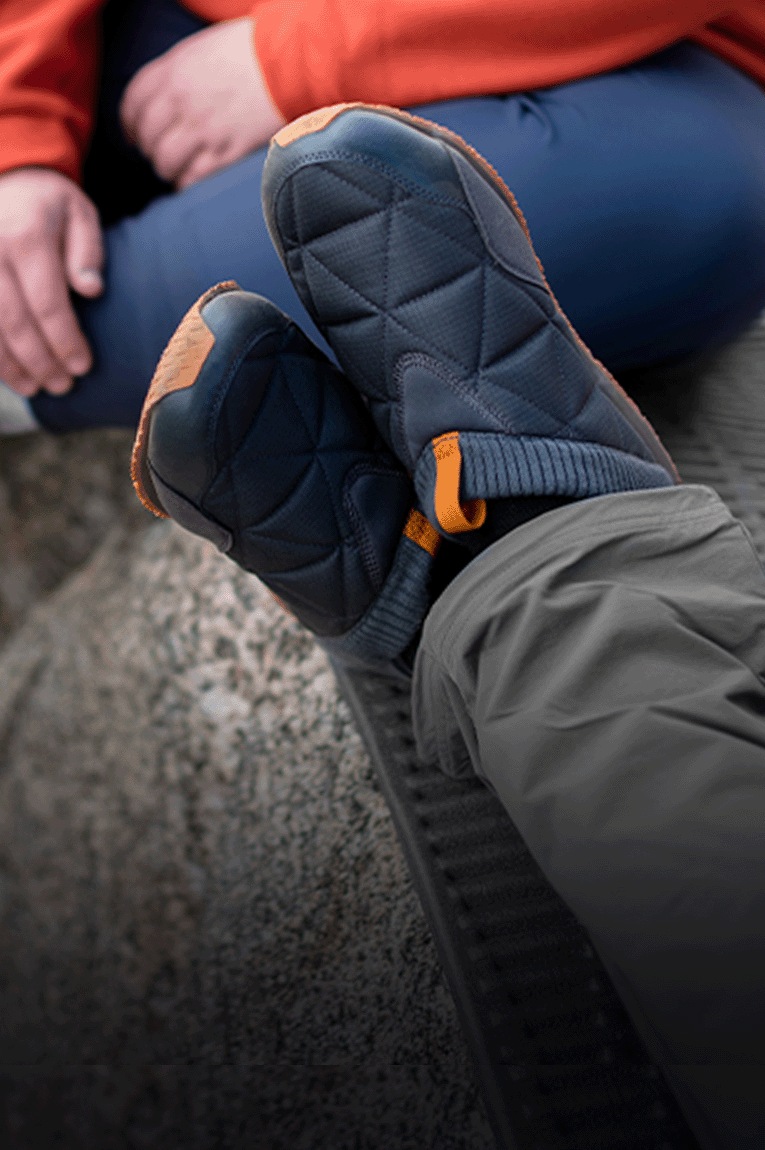 A camper wears the Teva ReEmber slip-ons at a campsite