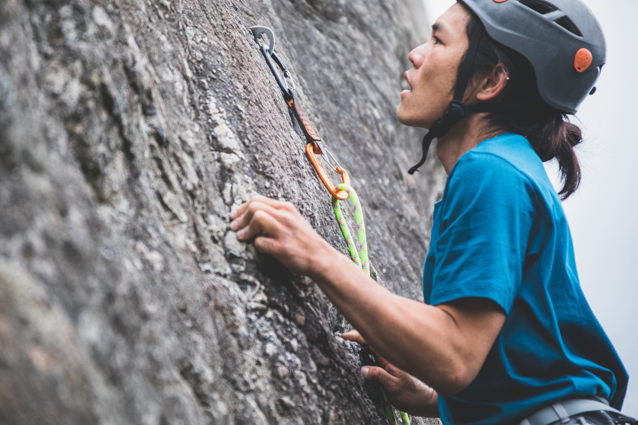 A sport climber clips the rope into a quickdraw