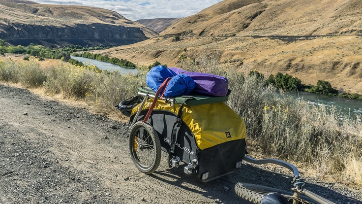Loaded bike trailer being towed behind a bike