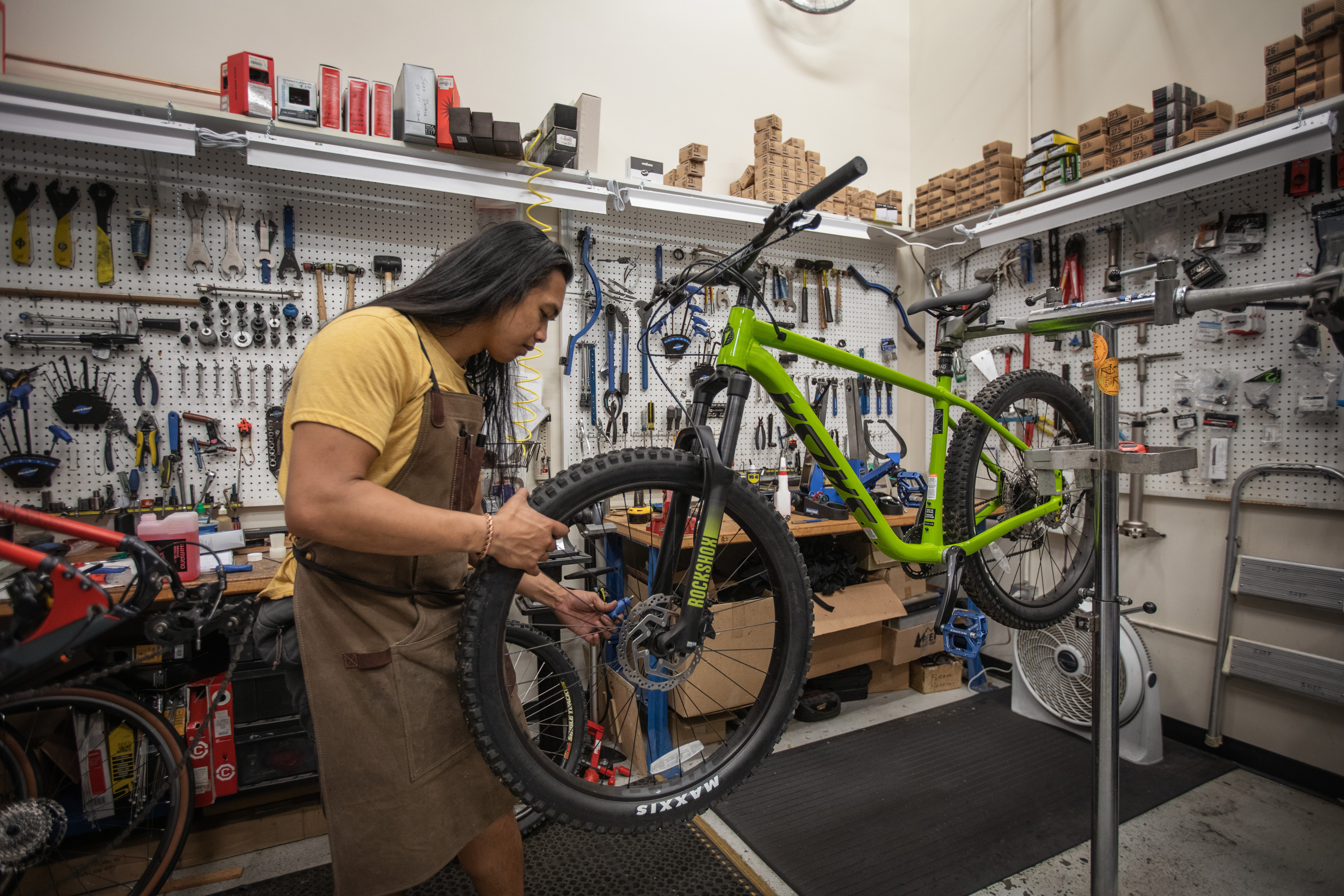 A person works on a bike in a shop.