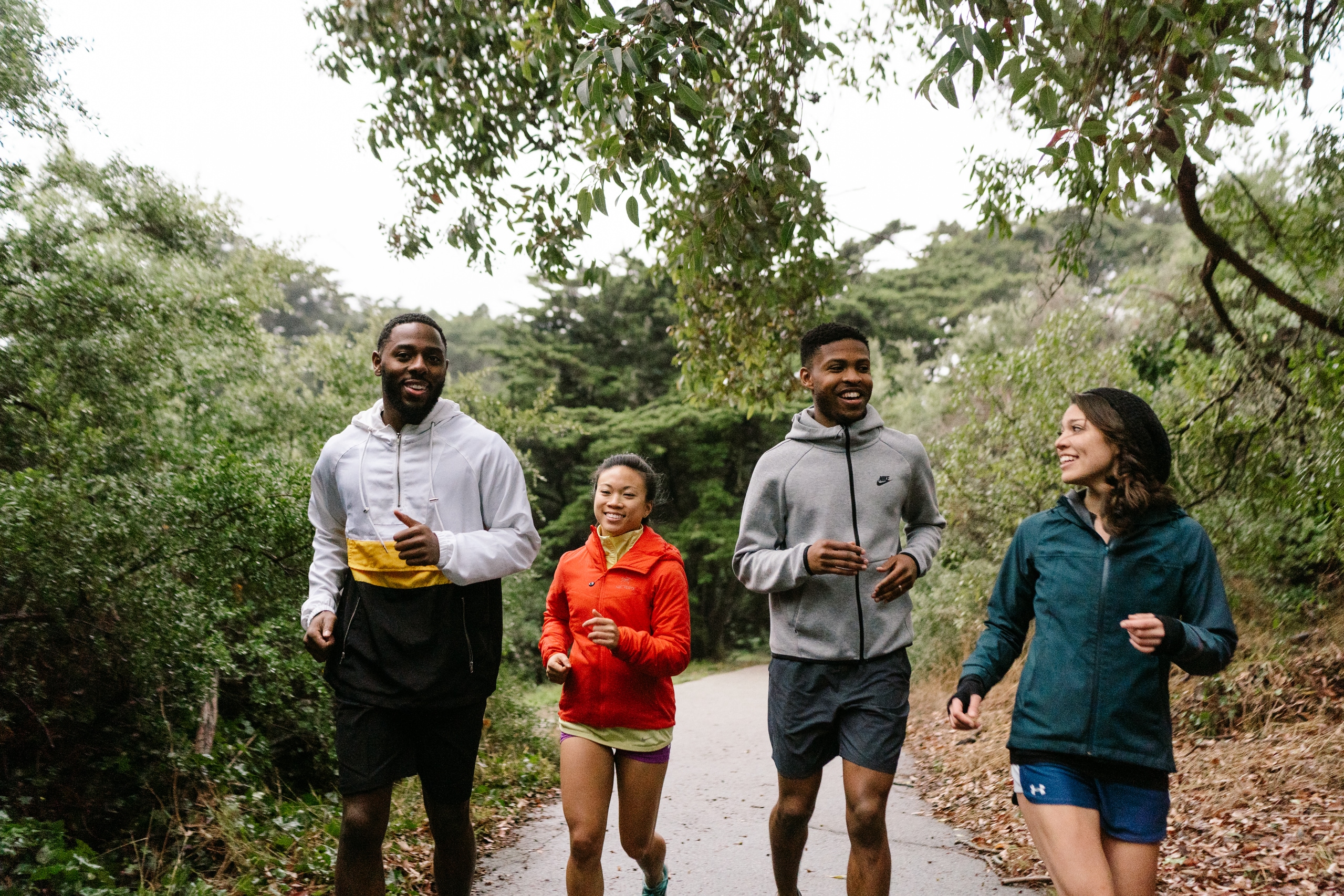 Four people running on a paved urban path