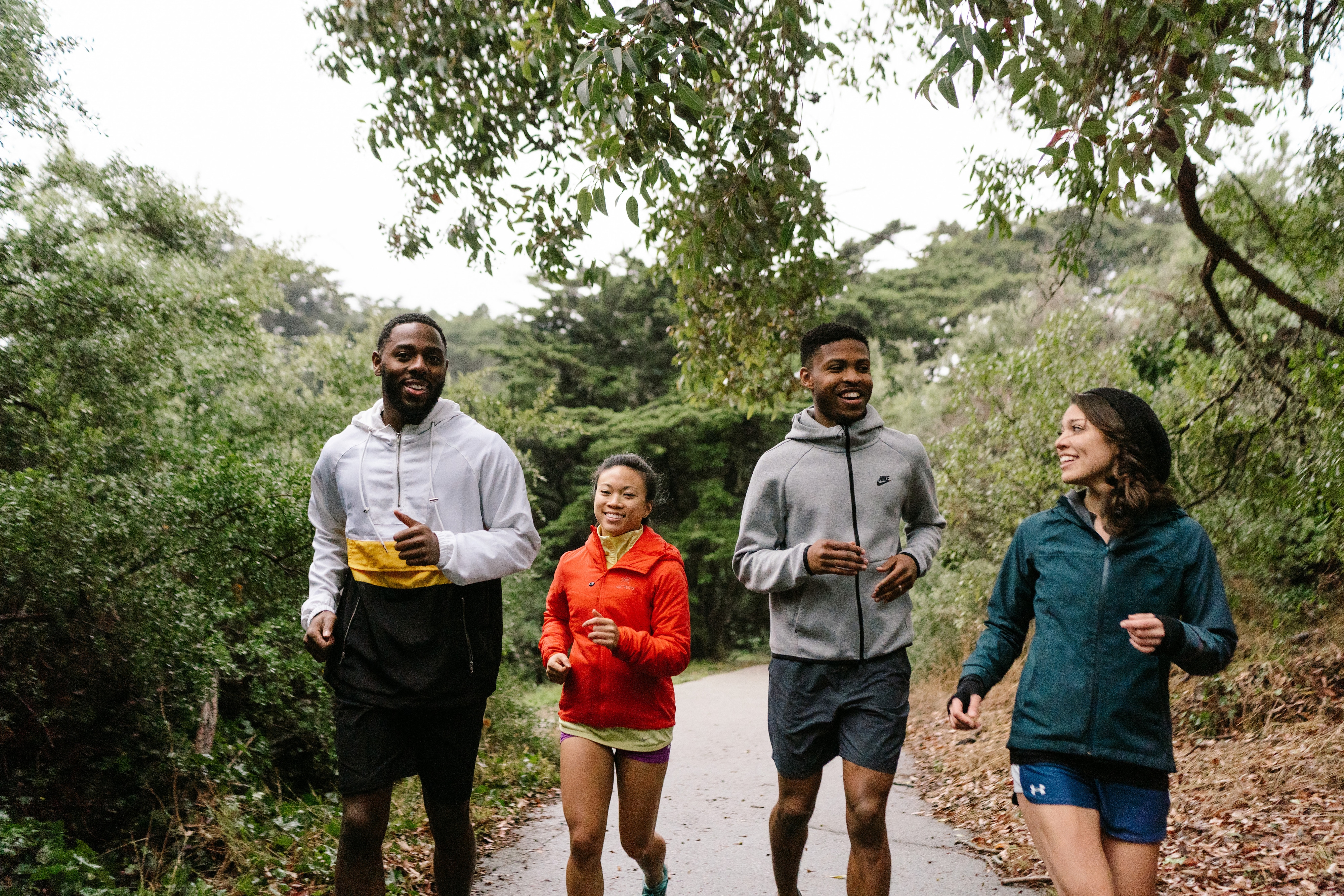 Four people running on a paved urban path