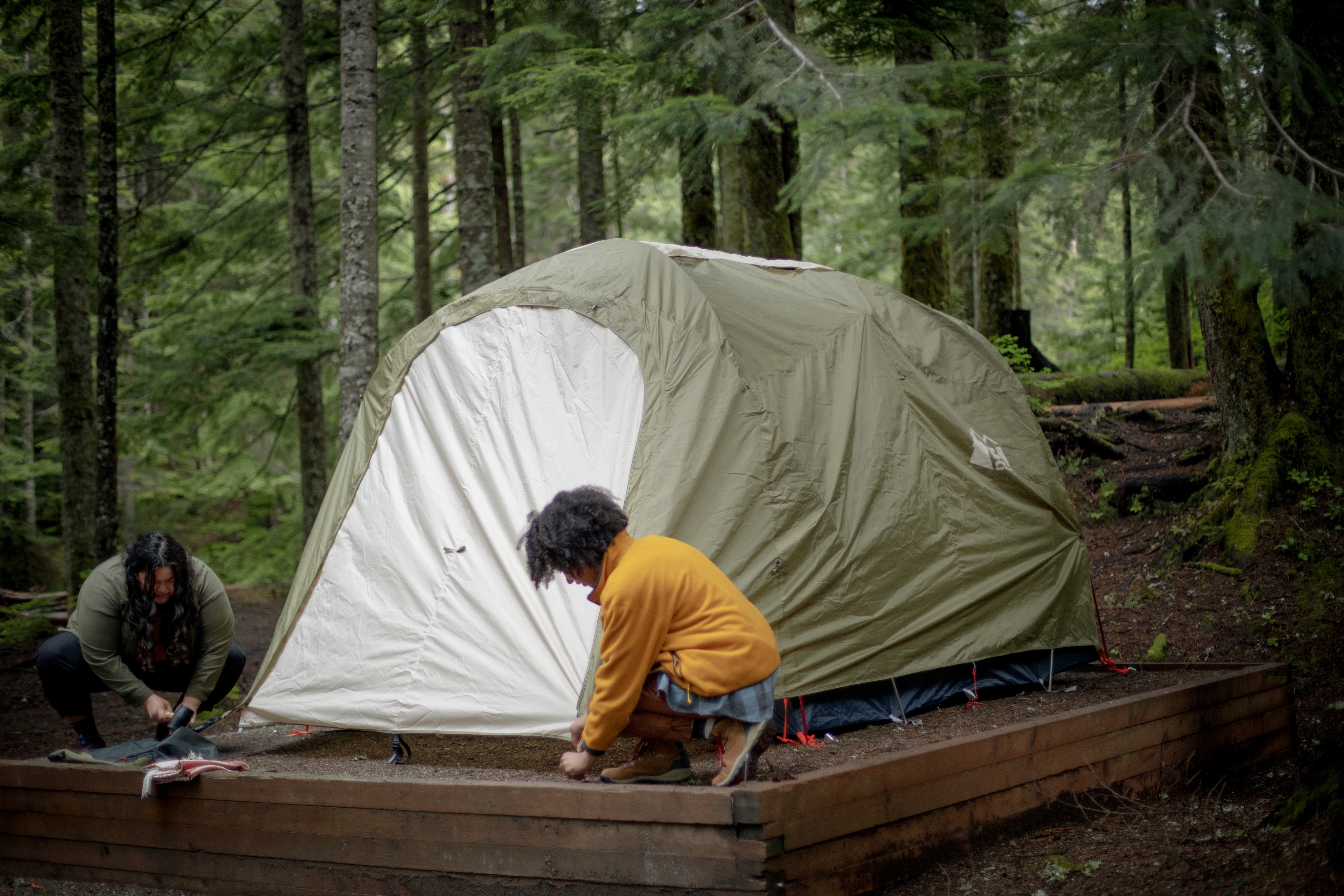 Two campers stake down their tent poles