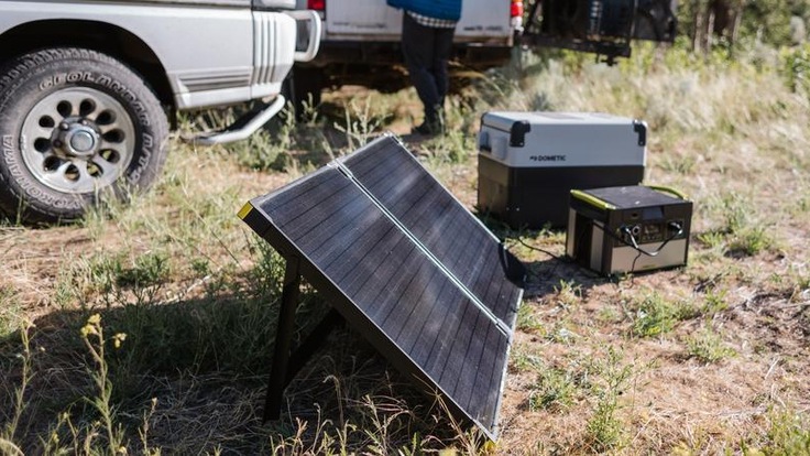 A solar panel absorbs energy from sunlight and provides electricity to a portable power station and an electric cooler