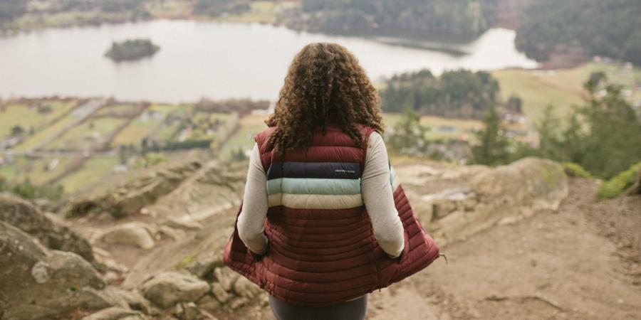 A person stands at high elevation overlooking the valley below