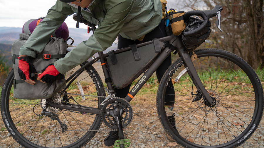 A person tightens the buckles on a rear bike pannier.