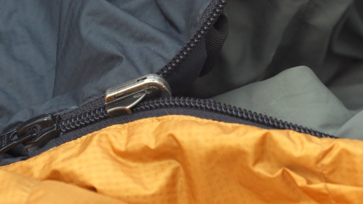 A sleeping bag zipper slider with a missing zipper pull