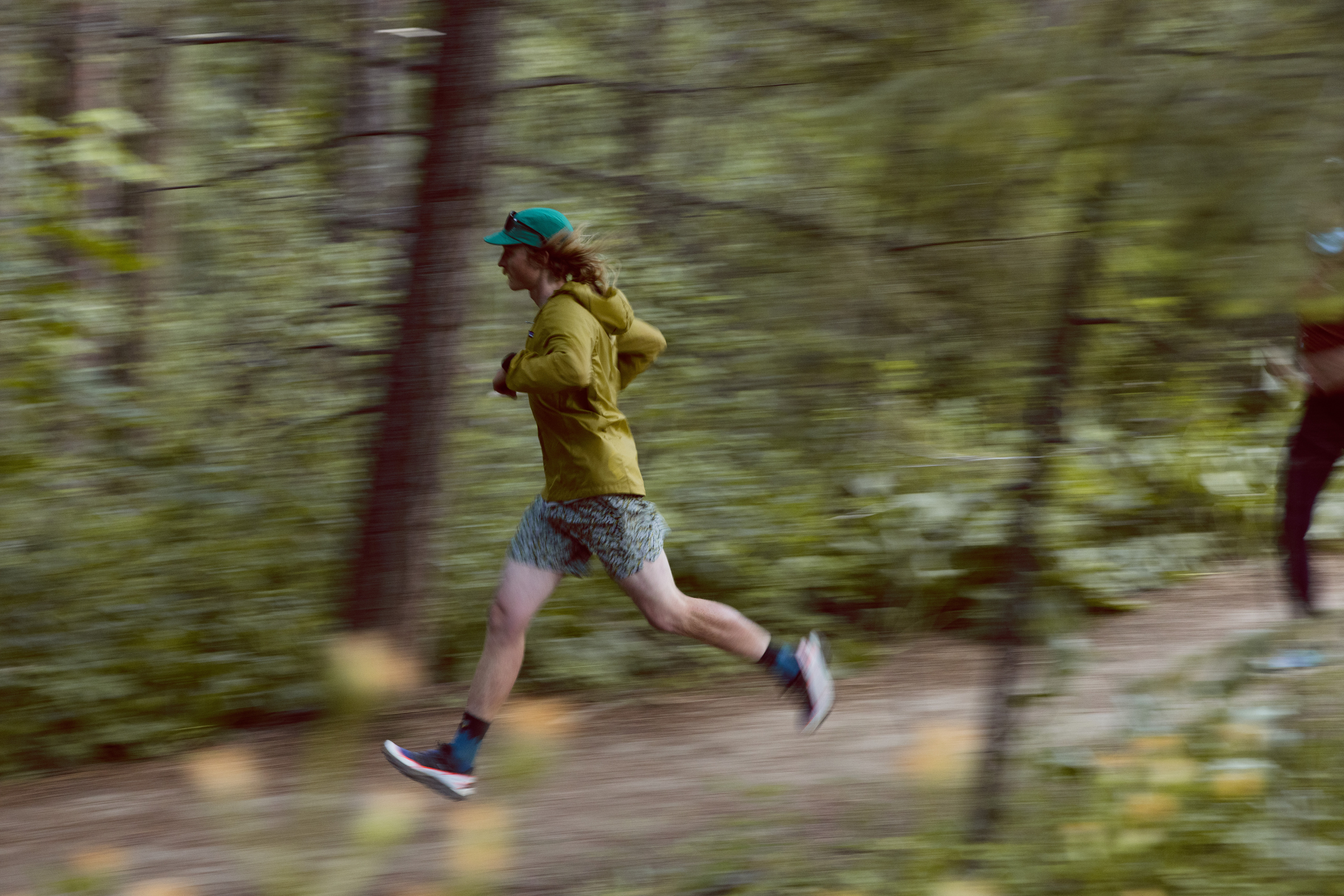 A person runs through a trail in a forest.