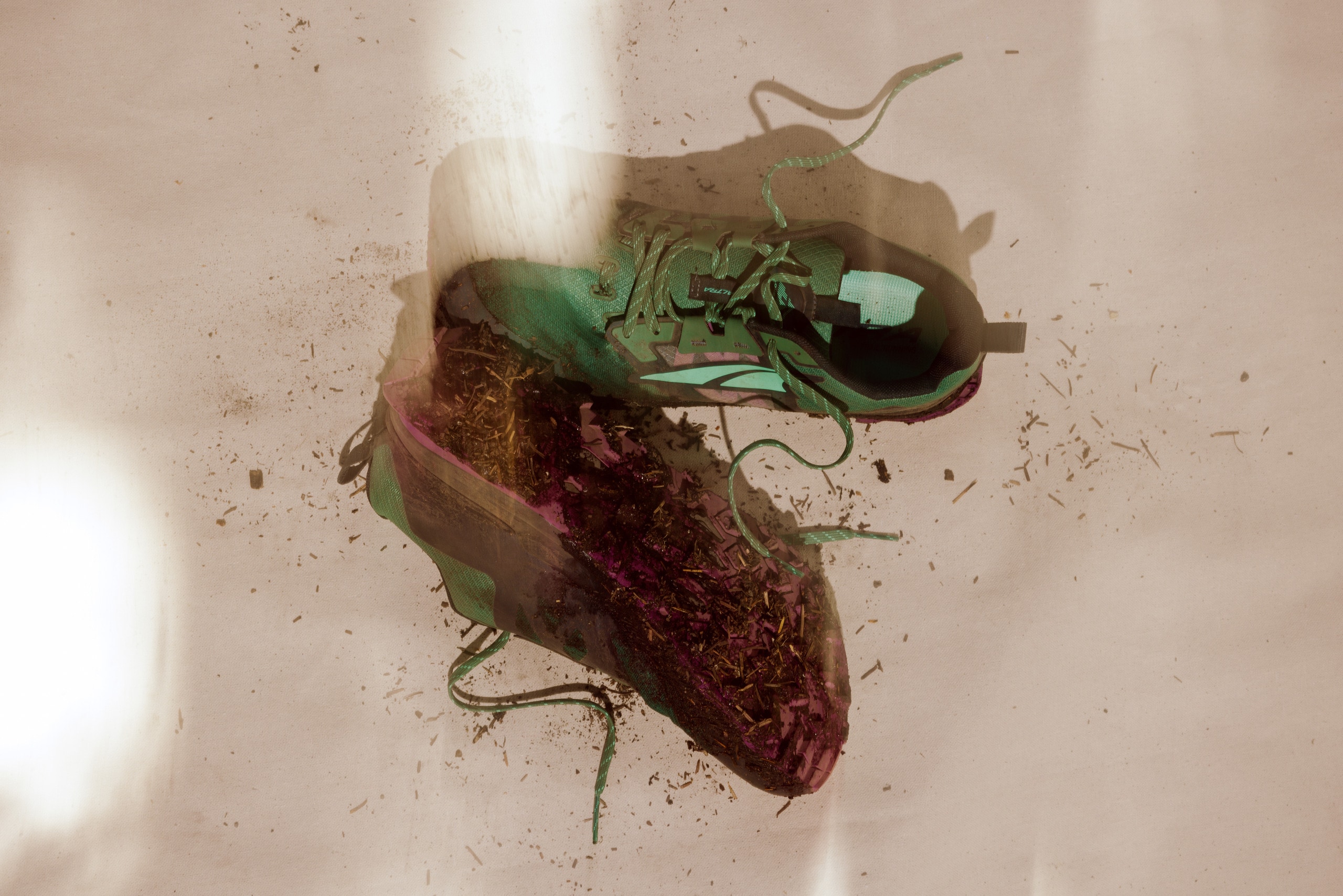 The Altra Lone Peak 7 splayed on the ground, covered in dirt from the trail