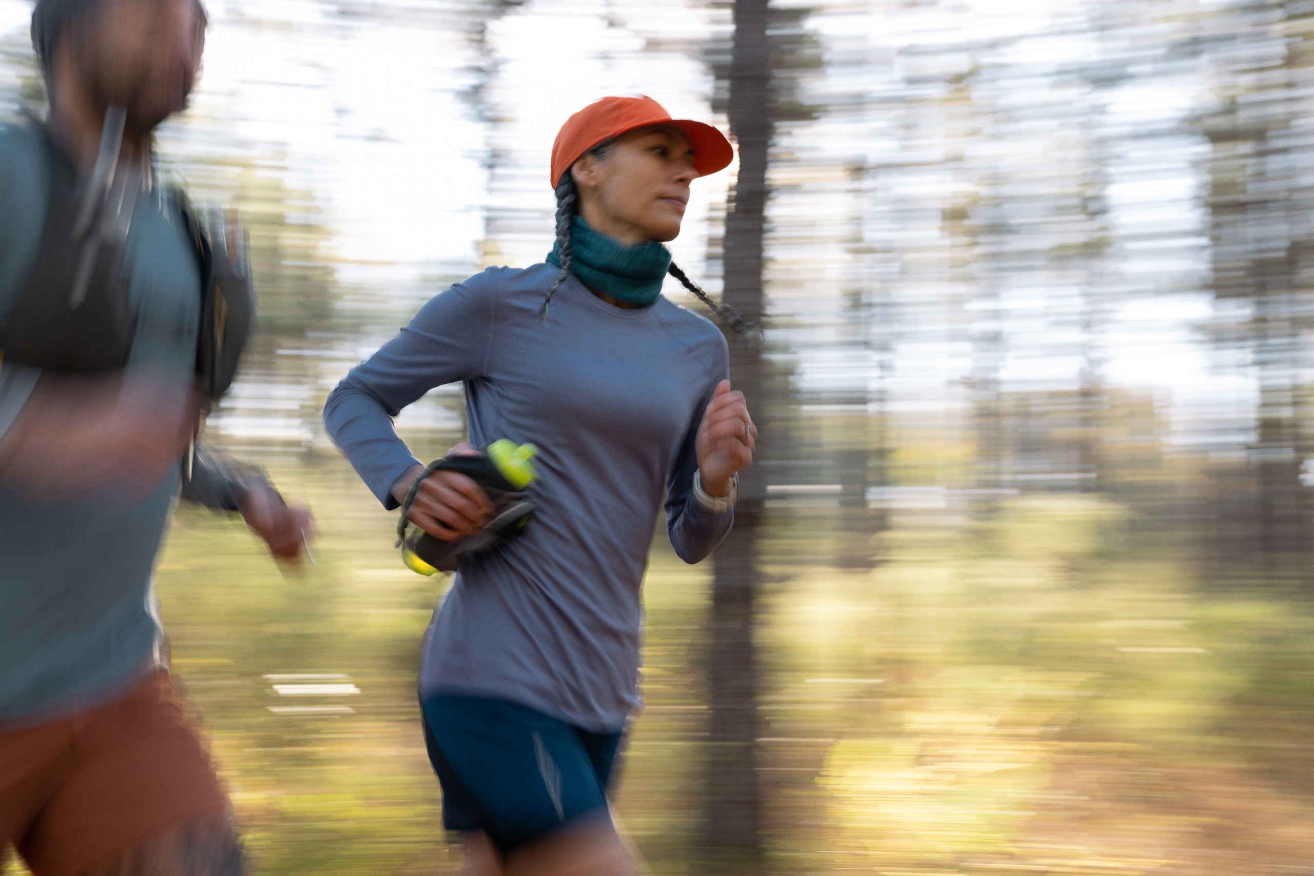 A person runs carrying a handheld water bottle