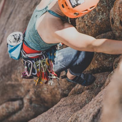 a rock climber placing their foot into a cliff wall