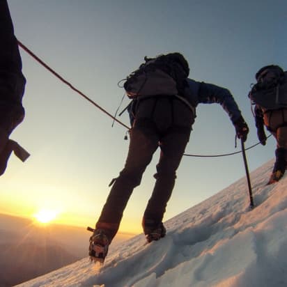 mountain climbers reaching a snowy summit