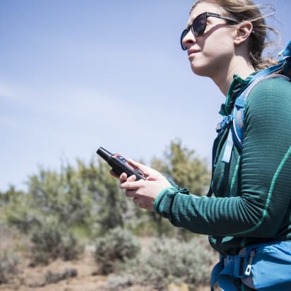 a hiker holding a handheld radio