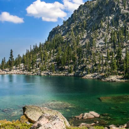 a clear blue lake surrounded by trees