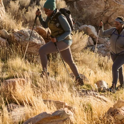 two hikers climb a hill