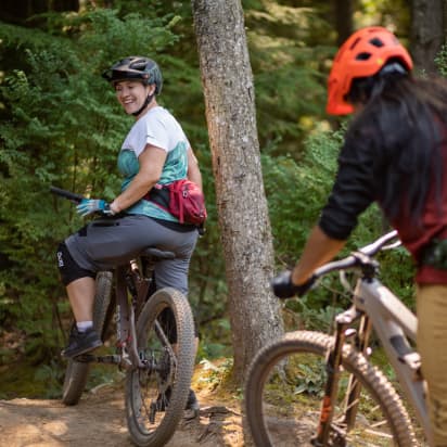 two cyclists pause for a break in the forest