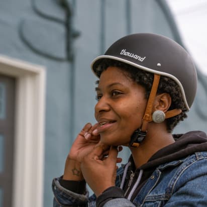 a cyclist straps on a helmet