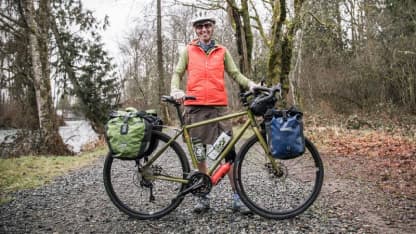 a cyclist poses with their bike