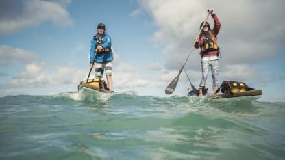two people paddle boarding