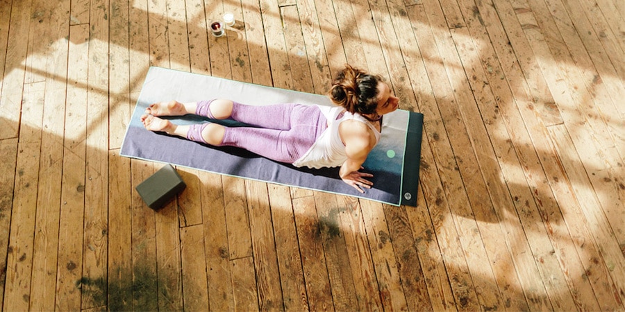 Woman lying on a yoga mat in a pose