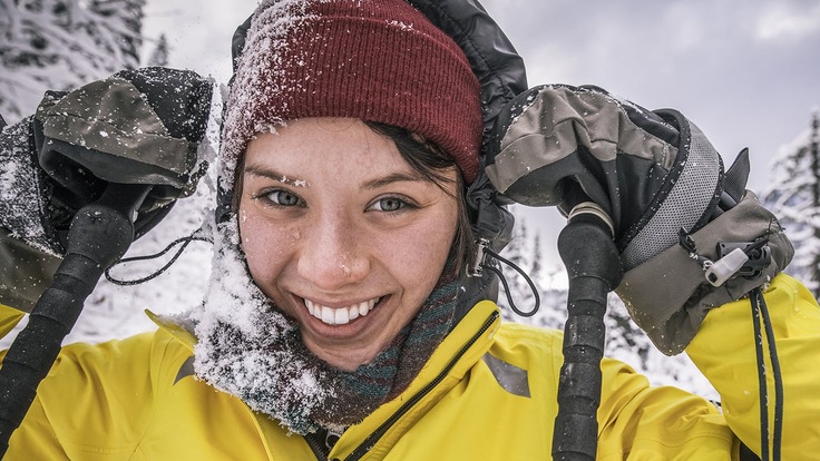 Person in snow with mittens on their hands