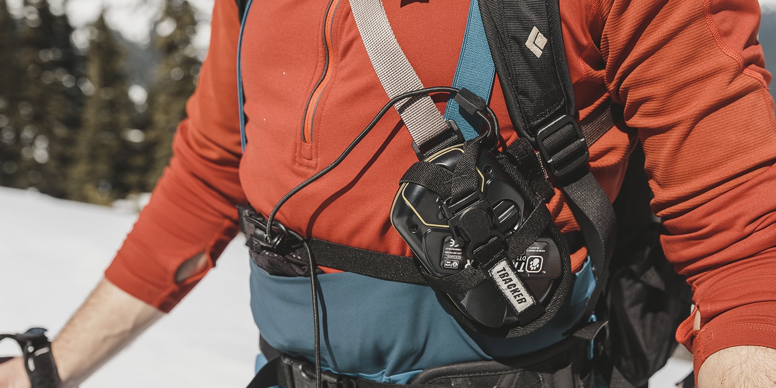 an avalanche tranceiver strapped across a man's chest