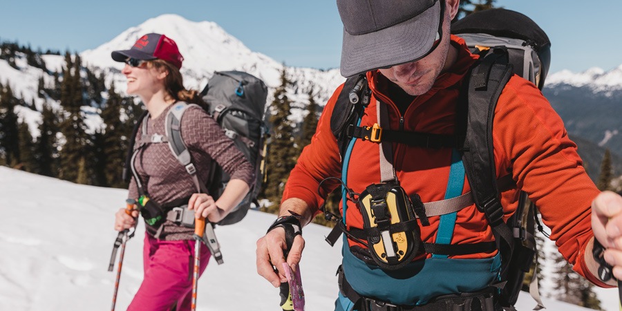 A skier in the backcountry wearing an avalavche transceiver