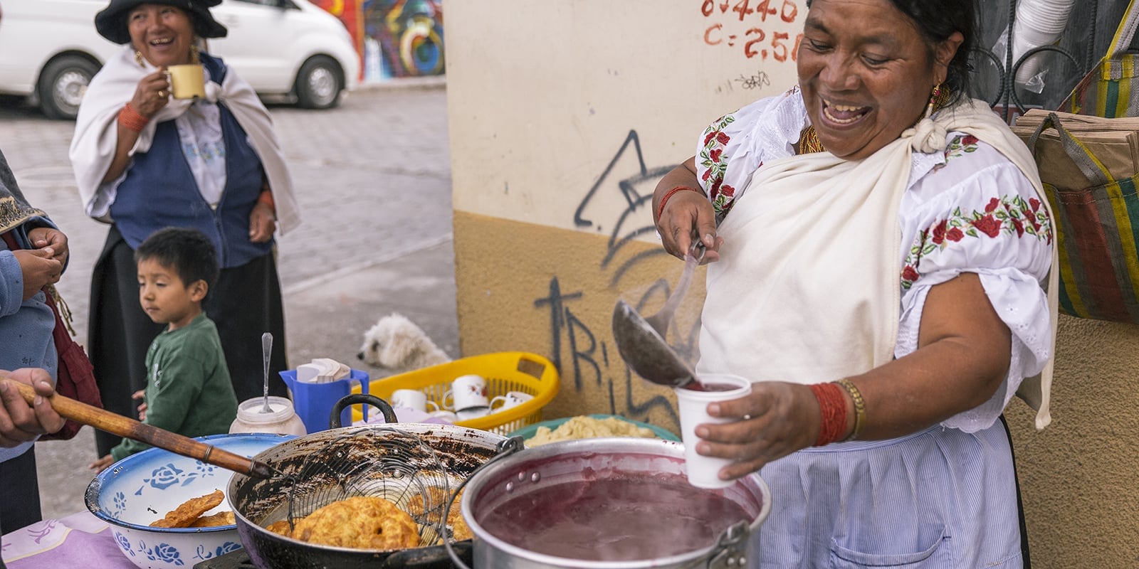 Woman street vendor ladling stew into a cup