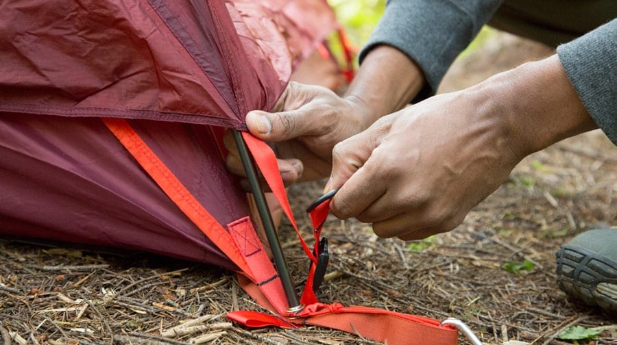 tensioning the rain fly over a tent corner