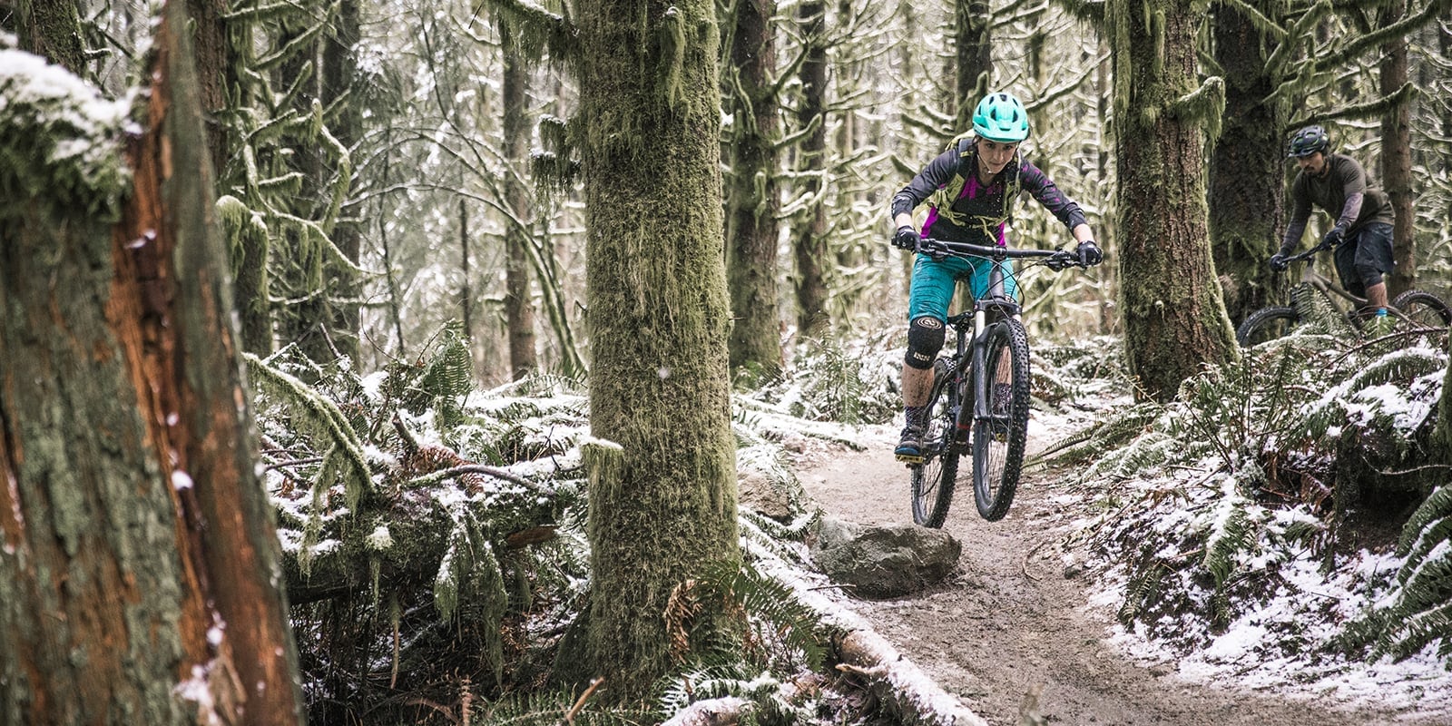 A mountain biker clearing an obstacle on the trail.