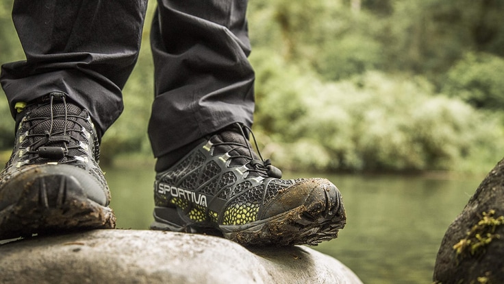 a hiker wearing a pair of muddy boots along the trail