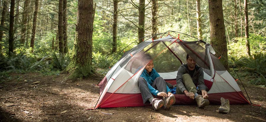 campers taking off their boots before entering their tent