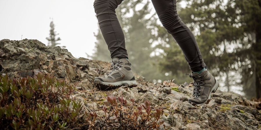 a hiker on a slippery rock surface on a rainy hike