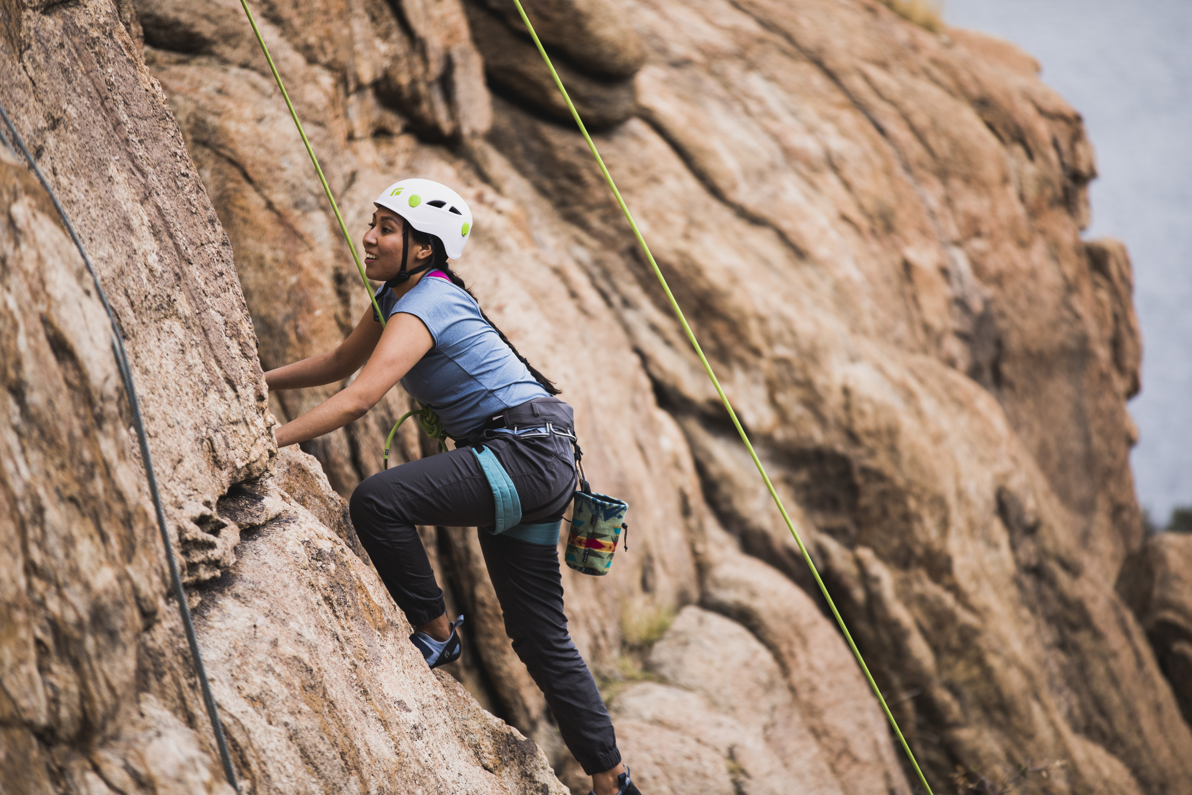 Woman climbing having a good time while wearing all safety gear