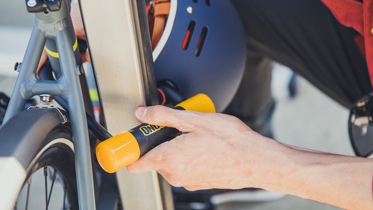 A cyclist locks up his bike and helmet with a u-lock
