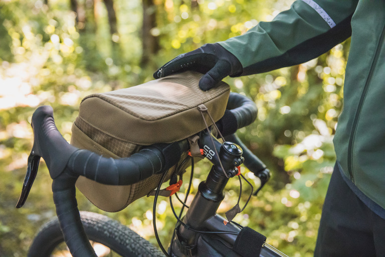 A handlebar bag fitted on a bike provides easy access to snacks, a cellphone and other items