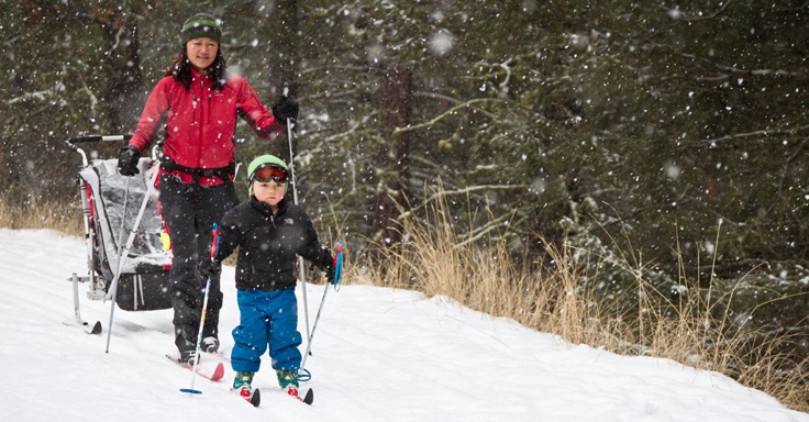 A parent and child cross country skiing