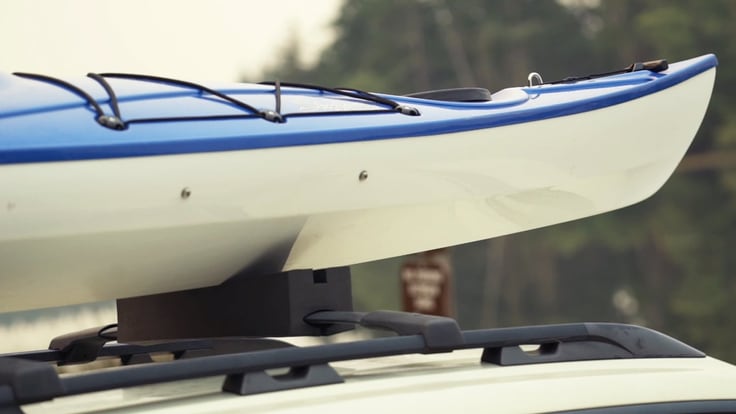 Front of a kayak mounted on top of a car rack
