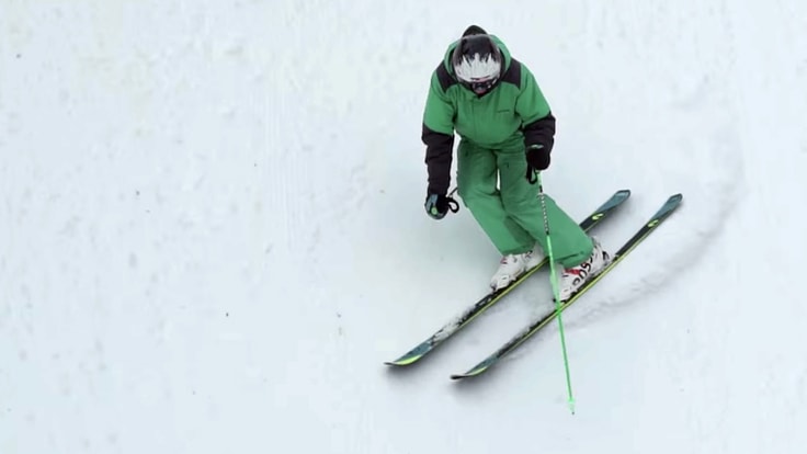 a downshill skier carving turns, as seen from above