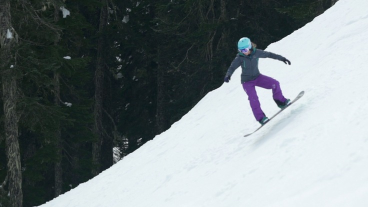 a snowboard in mid leap, while doing a leaper