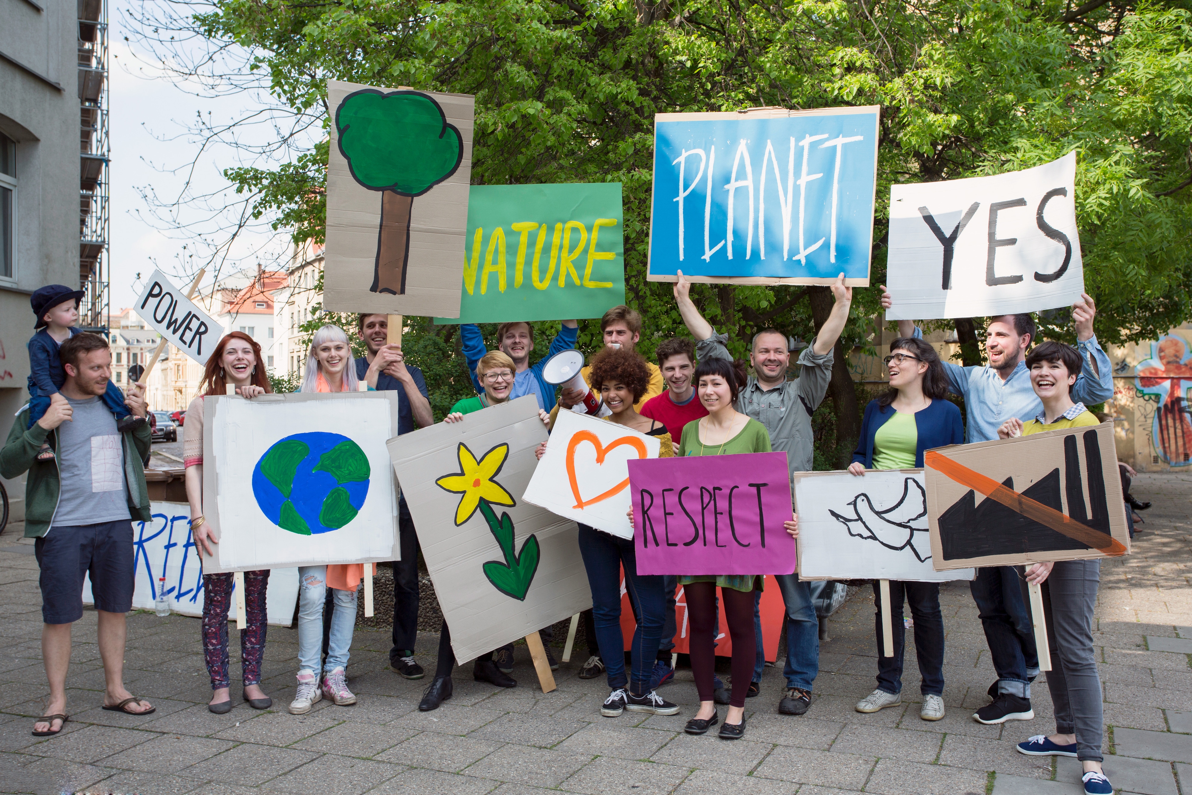 Group of people holding environmental protest signs outdoors.