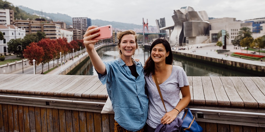 Two women taking a selfie on a bridge in Spain