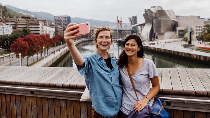 Two women taking a selfie on a bridge in Spain