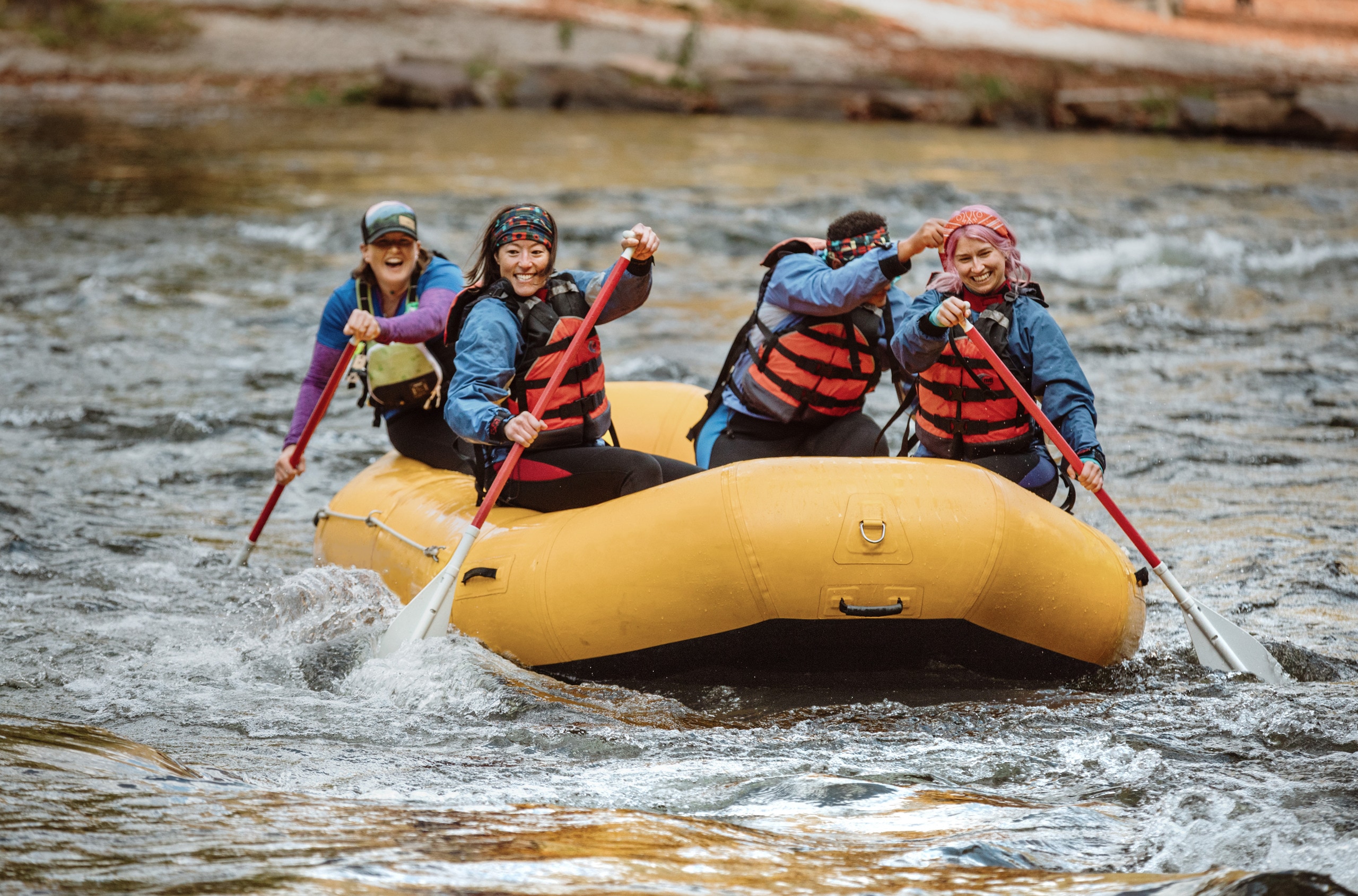 A group paddling in a large inflatable raft.