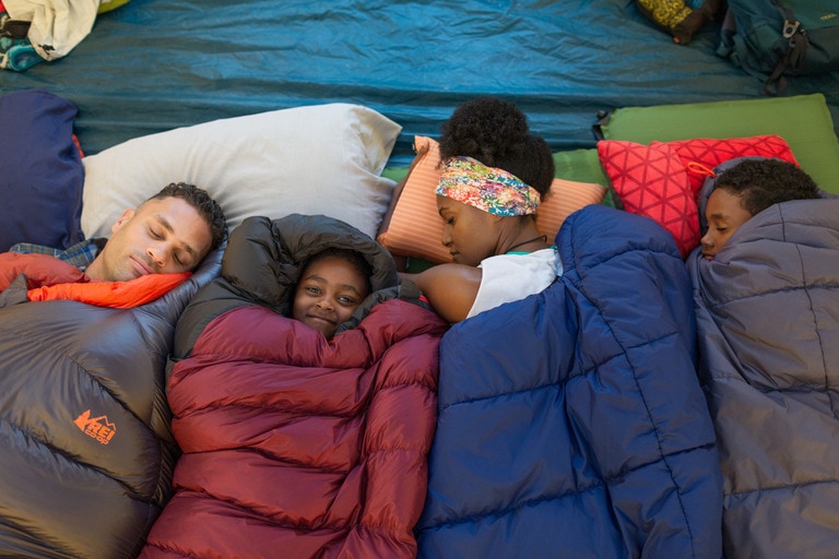 Family resting cozy in their sleeping bags