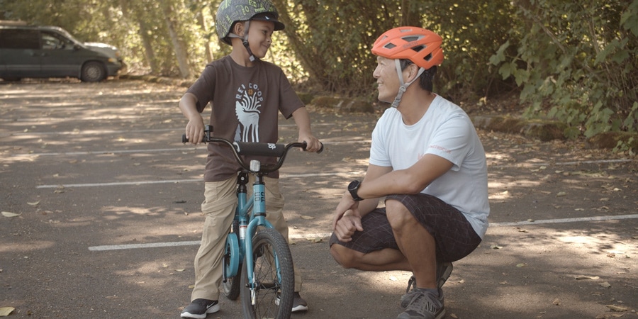 Un niño se sienta en una bicicleta con los pies apoyados en el suelo